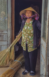 A broom-maker shows us her work.