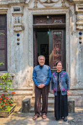 Couple in front of the beautiful home they once owned, lost, and now own again.