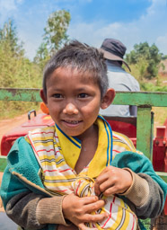 He has a secret!  He has a large piece of fruit wrapped in his shirt.  What a wonderful face!