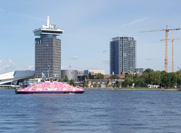 Odd sight, the pink pride boat!  The tall building behind it has swings on the roof that go out over the edge.  NO WAY!